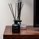 WILD & SPICY reed diffuser showcasing cardamom amber reed diffuser on a wooden table.